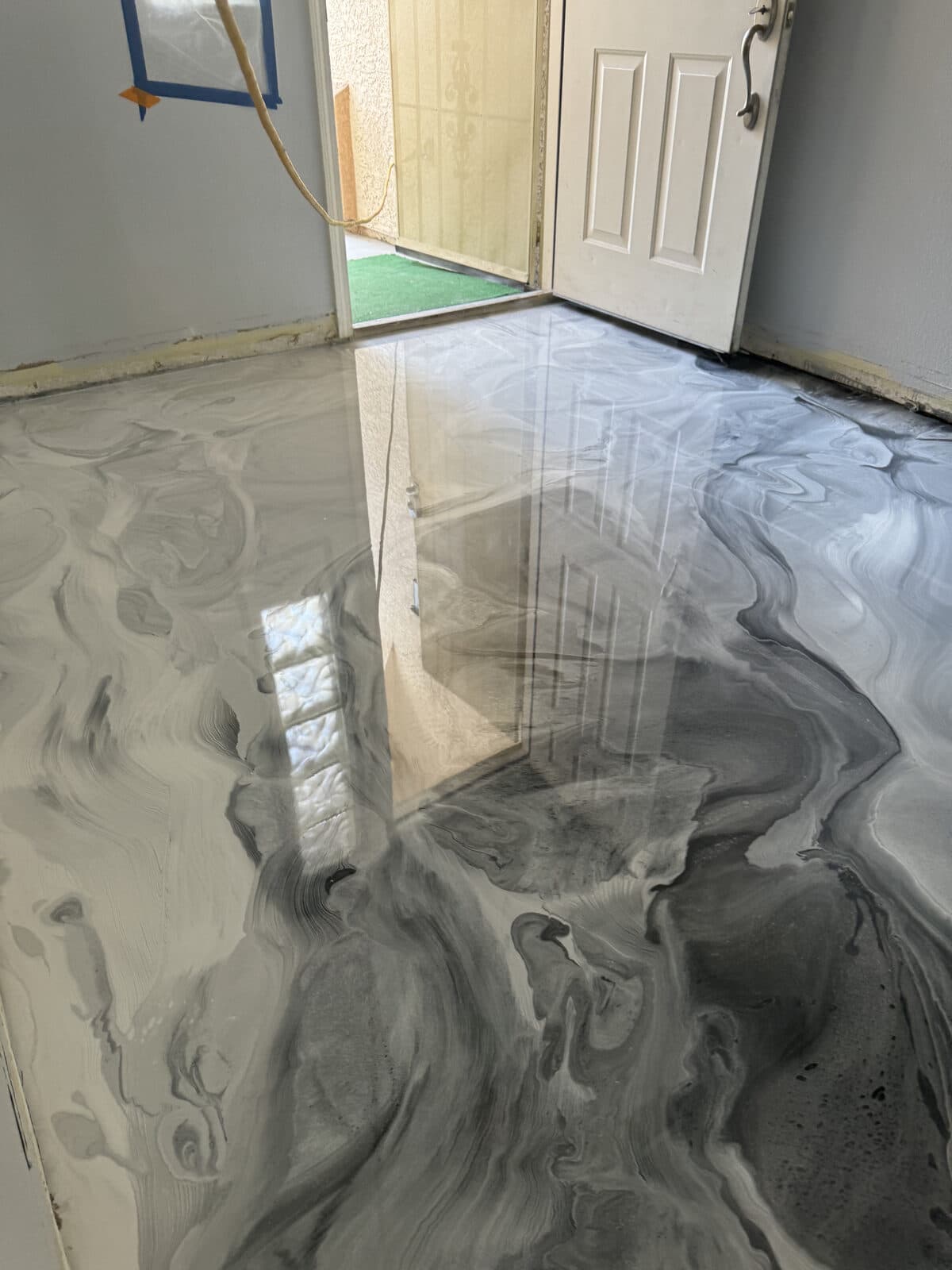 High-gloss metallic epoxy floor with mirror-like finish reflecting light — installed by ProShield Epoxy in Las Vegas