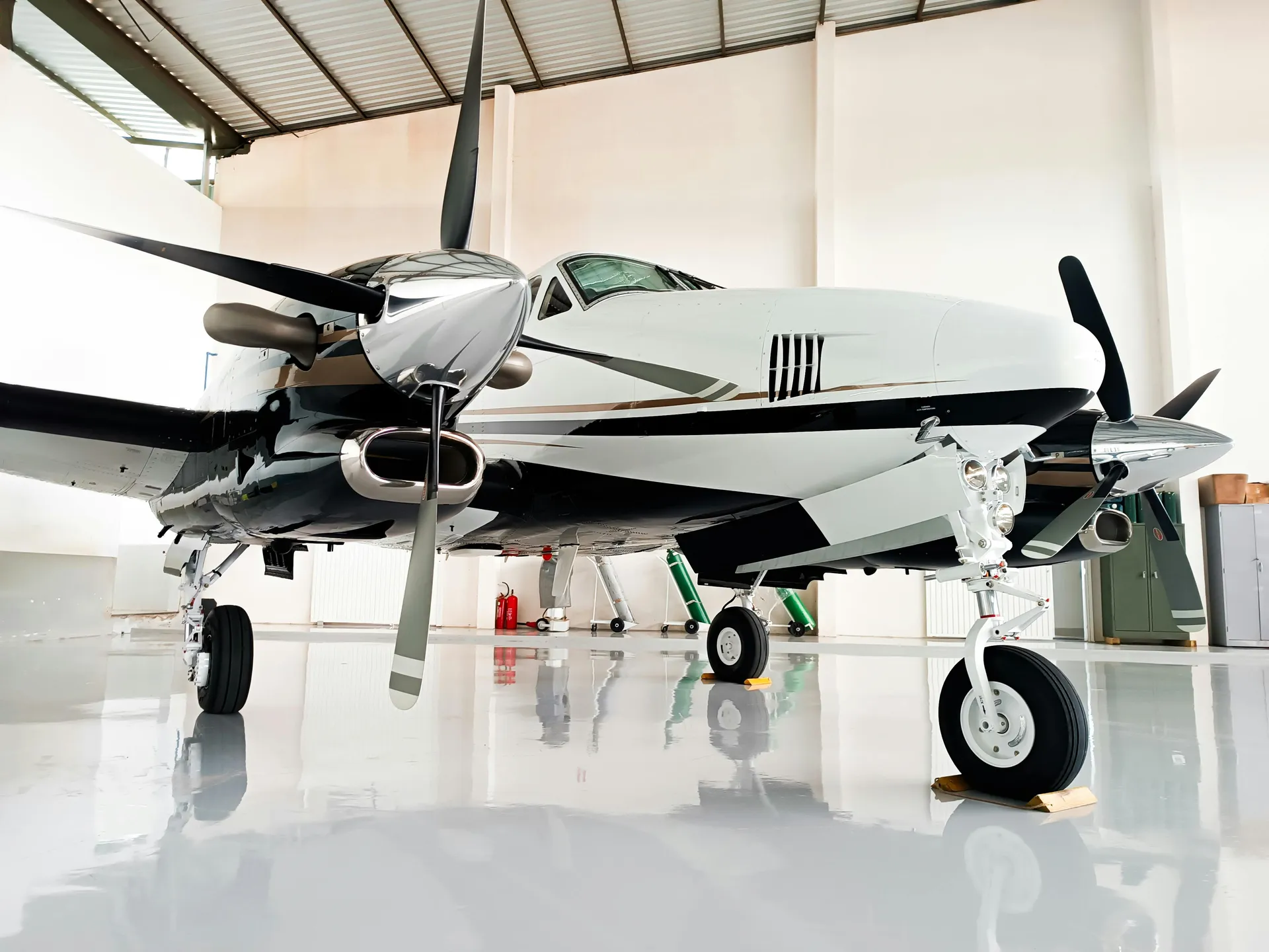 Turboprop aircraft parked on a glossy white coated hangar floor