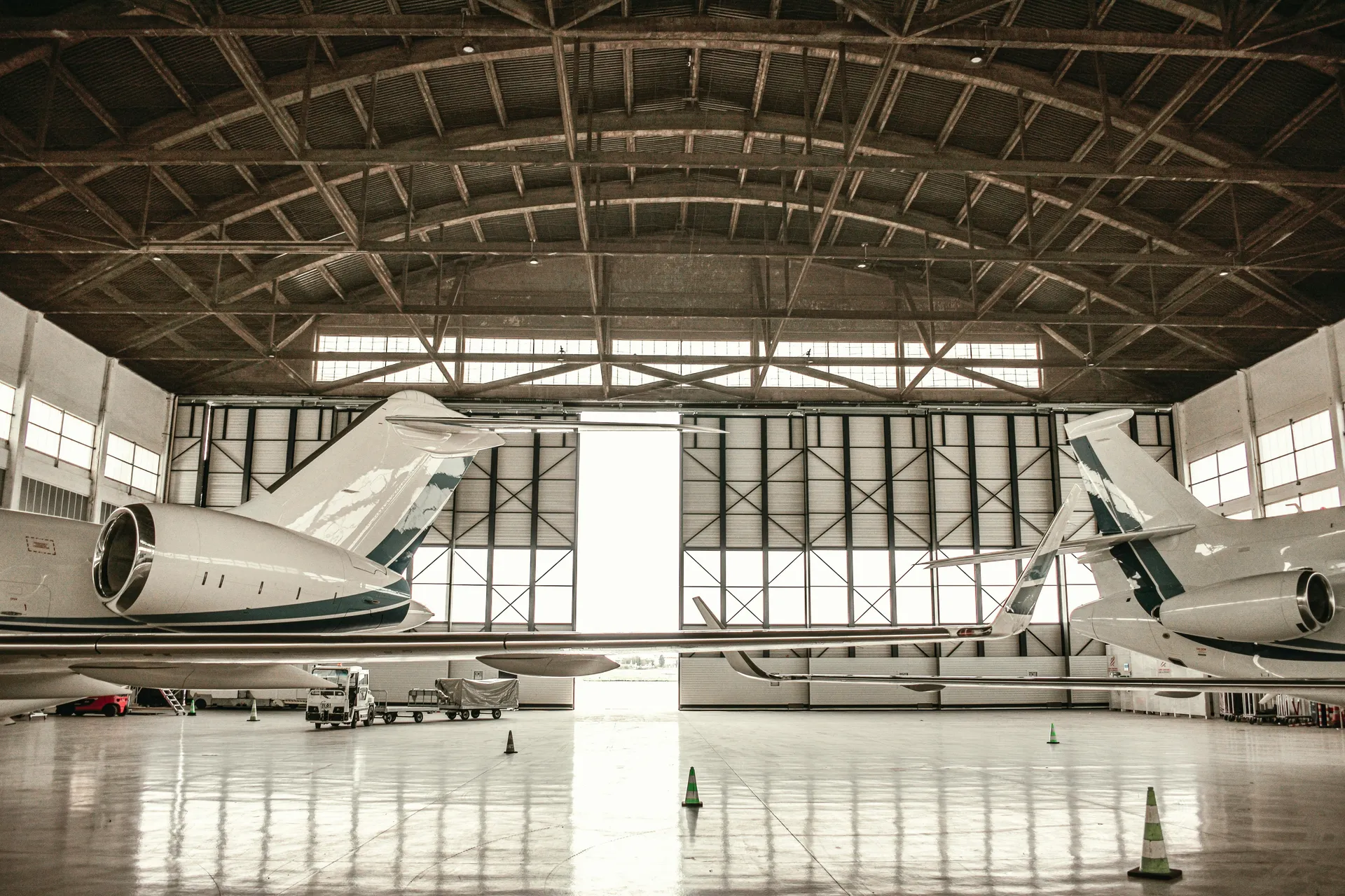 Private jets in a clean airplane hangar with glossy coated floor