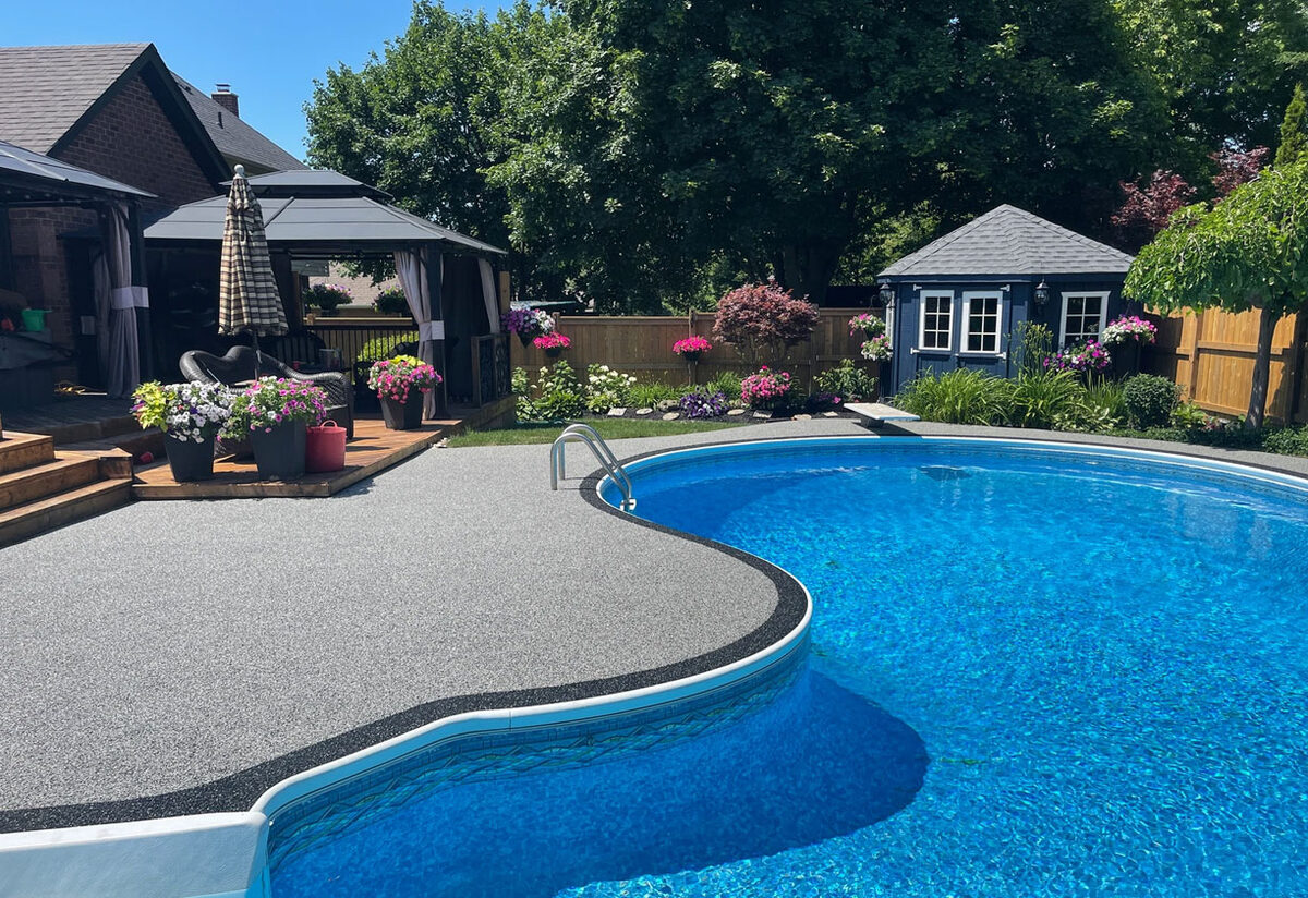 Rubber aggregate pool deck flooring around a Las Vegas pool with landscaping and gazebo — installed by ProShield Epoxy