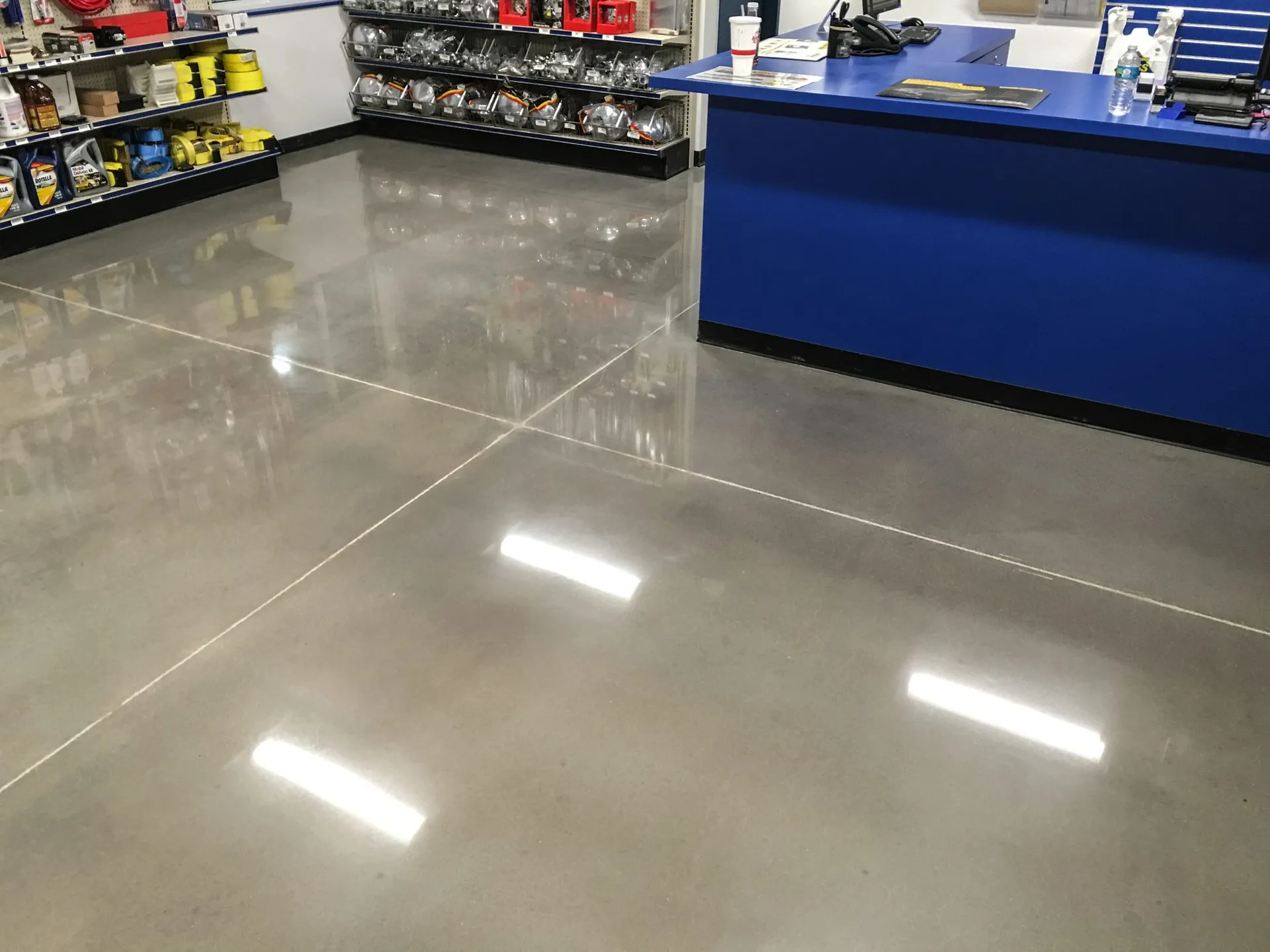 High-gloss polished concrete floor in a modern showroom with reflective mirror finish