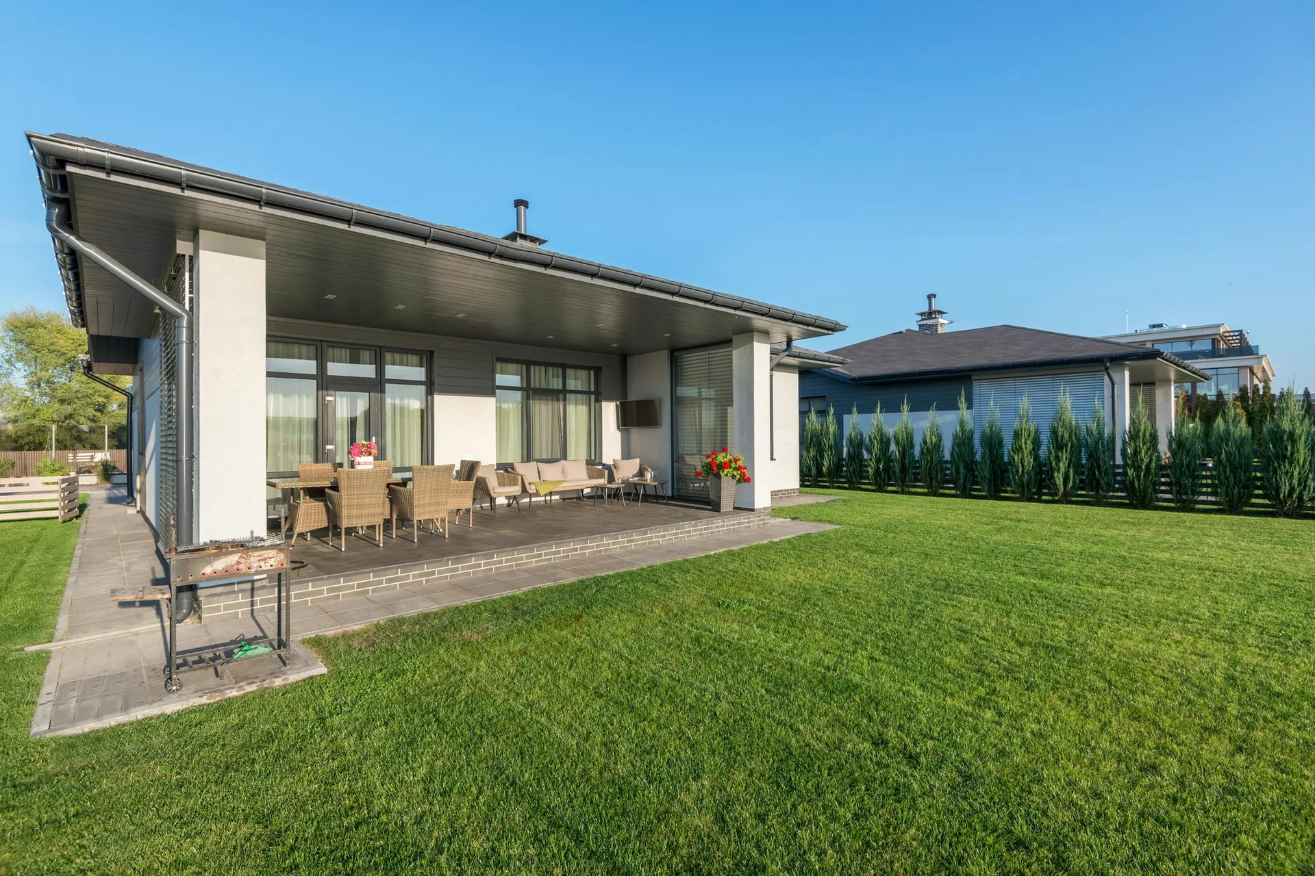 Modern home with pristine green lawn and patio area