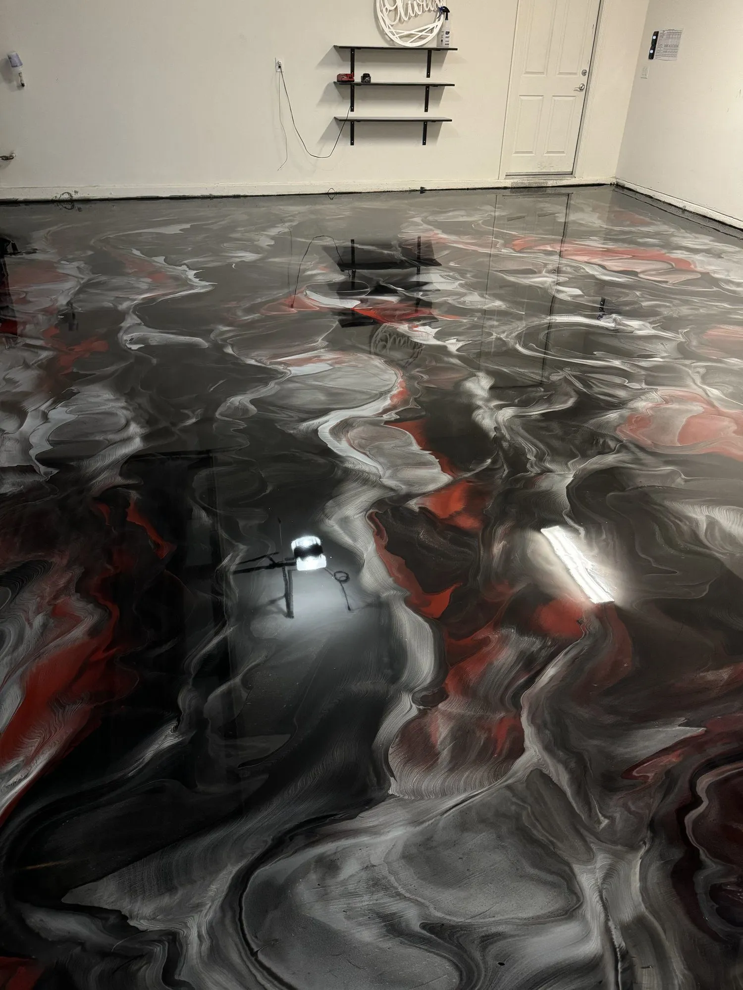 Metallic epoxy floor with red and black custom swirl finish — 3D liquid metal effect